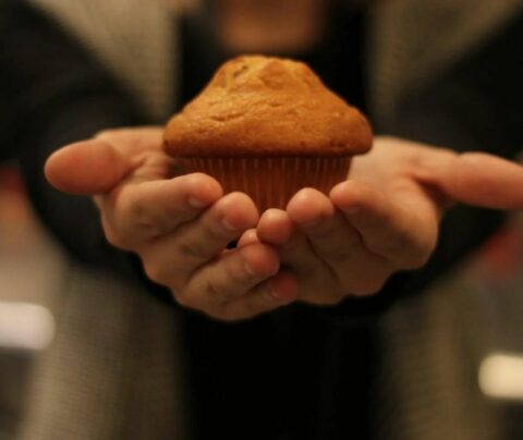 Muffin de Limón y Franbuesa sostenido por una persona.