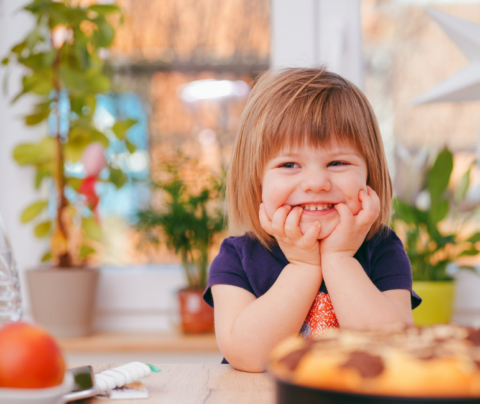 Niña sonriendo para la cámara, rubia, remera lila